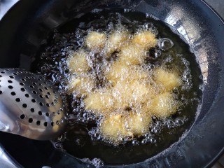 14、酥炸鱼翅南瓜丸子,炸定型后用漏勺轻轻推底。