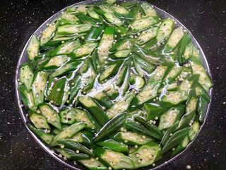 4、凉拌秋葵,锅里放入一大碗水，大火把水烧开，放入一勺盐，一勺油，少许白糖调匀，把秋葵放入焯1分钟。