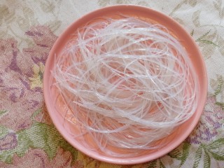 5、蒜蓉粉丝蒸金针菇,捞出粉丝平铺盘子里。