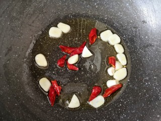 7、素炒白玉菇,炒锅内倒适量的食用油烧热，下入蒜片和辣椒段炒香。