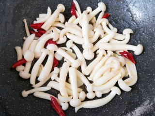 8、素炒白玉菇,下入白玉菇翻炒均匀。
