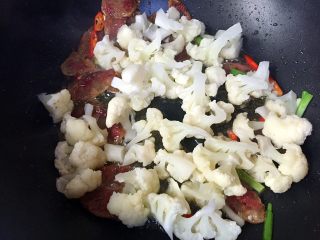 10、川味香肠炒菜花,再放入菜花翻炒一分钟。