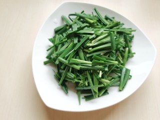 4、韭菜炒豆腐,韭菜择洗干净，韭菜根部割口处容易沾有泥土，不容易清洗，记得把最下边的根部切除，然后切成韭菜段。