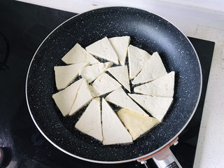 6、青椒炒豆腐,煎锅里倒油,中小火煎豆腐;