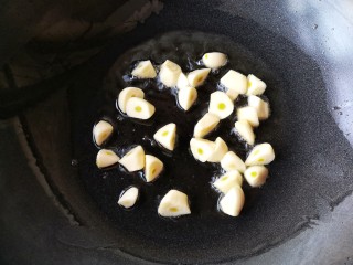 6、焦蒜皮蛋浸菠菜,锅中适量油，烧至七八成热，放入切好的大蒜。