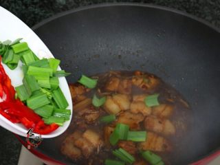 8、香辣下饭回锅肉,倒入蒜苗和辣椒，翻炒均匀即可