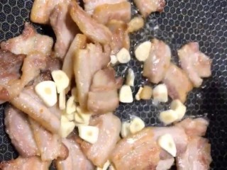 5、辣椒炒肉,放入蒜片炒香