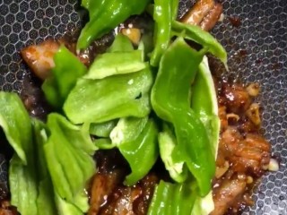 7、辣椒炒肉,下入撕好的辣椒，小火炒至断生