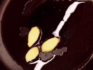 3、爆炒牛蛙,锅烧热后放入花生油，下姜片炒出香味。