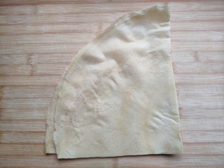 7、菜煎饼（韭菜鸡蛋馅）,馅料做好后，鼎鼎大名的山东煎饼登场。山东煎饼口味有多种:玉米，小米，还有五谷杂粮的。我买的是小米粉做的，颜色淡黄，不如玉米粉做的颜色黄。刚做好的煎饼整张是大圆形的，为了方便一般都先对折成半圆，再把半圆对折一次，叠成这种扇形(1/4圆)