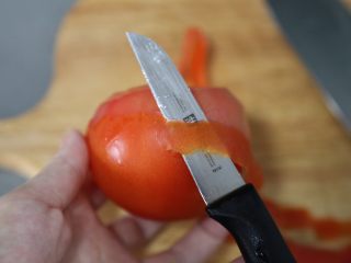 5、金针菇豆腐汤,番茄削皮,也可以用滚水烫一下,撕去外皮