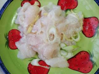 2、酸菜龙利鱼,斜刀片鱼片，加入葱丝姜丝橄榄鱼，调料包料酒，拌匀腌制30分钟。