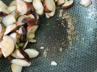 10、地三鲜,用锅铲将茄子推到锅边，放入大蒜末