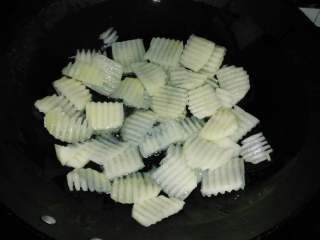 3、地方菜≈干锅排骨≈,锅中倒入适量的油，倒入土豆片煎