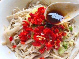 7、手撕杏鲍菇,把调好的酱汁均匀的浇在杏鲍菇上面。