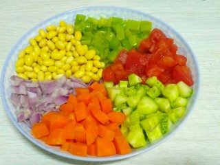 3、素什锦凉面,热锅内下10克油，倒入青椒快速翻炒20秒出锅。将青椒，黄瓜丁，西红柿丁，以及前面抄水的黄豆芽胡萝卜装盘备用。