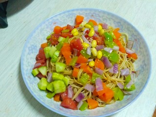 6、素什锦凉面,将面条装入盘中，调汁和蒜水浇入面条，加入鸡精拌匀，最后可以淋上辣椒油或者香油。根据个人喜好将准备好的蔬菜粒均匀撒上去。