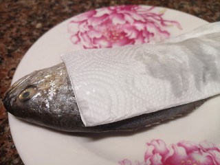 3、酱焖黄花鱼,用厨房纸吸掉鱼身上多余的水，以防煎鱼的时候溅油。