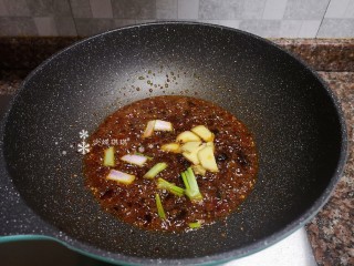 9、酱焖黄花鱼,放入葱头和生姜片爆香。