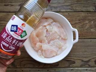 3、酸汤龙利鱼,在片好的龙利鱼片中加入一勺料酒。