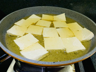 4、油菜豆腐,五成热时,把切好的豆腐放入油锅中炸;