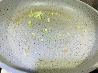 16、油菜豆腐,把煎豆腐的剩油倒起来,锅里剩点油,开大火放入葱白炒香;