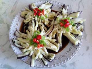 10、菊花茄子,将蒜末，青尖椒，小米椒依次放在茄子中间位置作为花蕊装饰