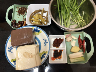 1、猪血炖豆腐➕红白花开山雨中,食材合照：猪血一块约350g，嫩豆腐一块约450g，韭菜50g，蒜4瓣，小米辣4个，姜一小块，葱白一小块，泡椒七八个，泡豇豆两根，花椒一小把，干辣椒六个，郫县豆瓣酱一汤匙，川味香辣酱半汤匙