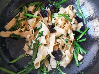 9、韭香豆腐皮,根据个人口味再加入适量的盐和鸡精，大火翻炒均匀，韭菜断生即可出锅。
