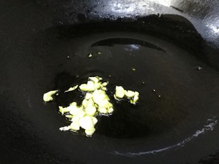 4、青椒炒口蘑,热锅倒入适量油，油温热放入蒜末炒香。