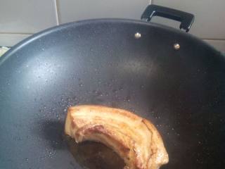 2、懶羊羊扣肉,锅里放四勺油，放五花肉煎至变黄，有皮的一面要煎久一些，煎好盛起，放凉一会再切