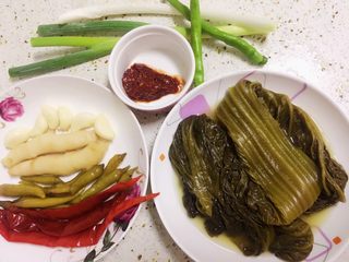 3、酸菜烧鱼,然后准备好配料:自己做的老酸菜、泡椒泡姜大蒜,剁细的豆瓣酱,大葱。我搭配了两根青辣椒和一根芹菜,用来装饰装盘用。