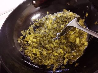 7、酸菜烧鱼,锅里倒入适量油,烧热后放入酸菜炒香。