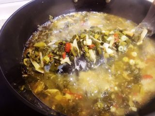 11、酸菜烧鱼,盖上锅盖大火煮八到十分钟(时间以鱼的大小来调整),中途打开一次将鱼挪动地方以免粘锅,并将酸菜配料和汤汁浇在鱼的上面。盖上锅盖煮。最后关火。