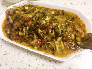 16、酸菜烧鱼,将勾芡后的汤汁均匀浇在鱼身上。
