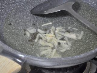 4、茭白炒肉,倒入蒜末，炒出香味。