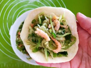 30、角瓜虾仁馅麦穗包子,取一个面皮,加入2勺角瓜虾仁馅料