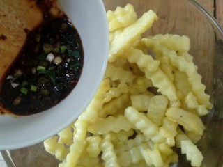 14、凉拌狼牙土豆,再把刚刚调好的酱汁倒入碗里搅拌均匀即可