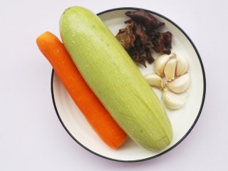 1、超简单的家常素炒西葫芦,准备食材:西葫芦一根,胡萝卜半根,木耳30g,大蒜适量。