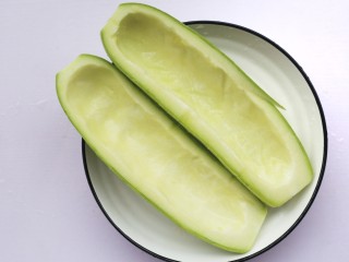 2、超简单的家常素炒西葫芦,西葫芦对半切开,挖去里面的籽。