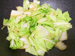 6、大白菜炖粉条,下入白菜叶翻炒均匀。