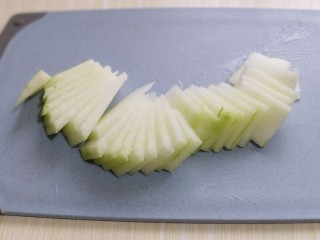 3、虾蓉蒸冬瓜,取一块冬瓜切薄片，不要切的 太薄，那样蒸熟后夹不起来，将两块冬瓜切完。