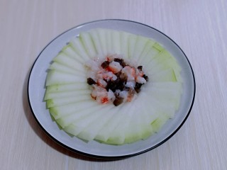 9、虾蓉蒸冬瓜,将腌制好的虾蓉及海参放在冬瓜盘的中间，如图。