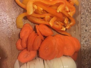 6、另类回锅肉,冷水浸泡肉的时候,把菜椒切成细条,胡萝卜和洋葱切成块儿。