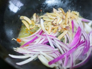 5、墨鱼杂蔬炒螺丝意面,锅中加入30克玉米油烧热后倒入墨鱼、洋葱一起煸炒出香味。