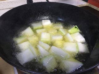 3、红烧冬瓜 下饭菜,用锅铲翻一翻。让冬瓜受热均匀。翻冬瓜时。可以加大火。过油的过程需要耐心等待。