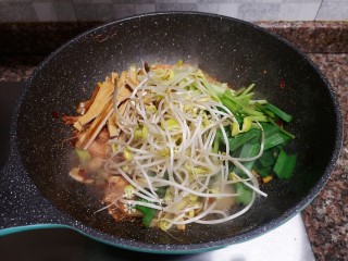 12、麻辣干锅虾,放入豆芽、豆腐干和蒜苗叶翻炒均匀。