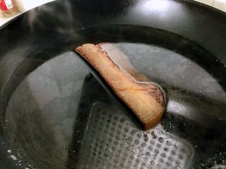 2、切片腊肉,腊肉用温水洗干净污渍，泡在清水中过夜或者大半天，清水要量足，因为腊肉盐分太重，泡有两重作用，一是让晾了长时间肉变软，二是减轻盐分。我认为第二太重要了，如果是一块咸咸的肉吃进去，除了难以下咽外对身体没有任何好处，别谈美食了，有的腊肉制作时怕会坏，所以盐分很重。如时间允许，泡的过程中可换两三次水。