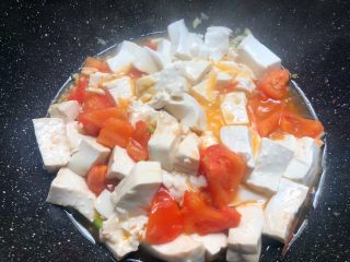 7、番茄烧豆腐,加入豆腐翻炒均匀,加入5克蚝油,10克生抽,适量盐,50毫升水炒匀,盖上盖子焖5分钟。