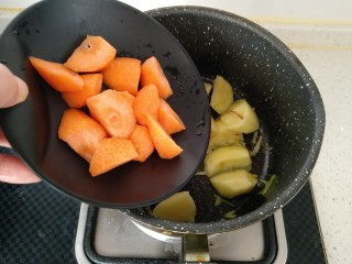 8、咖喱牛肉饭,倒入胡萝卜继续翻炒均匀。